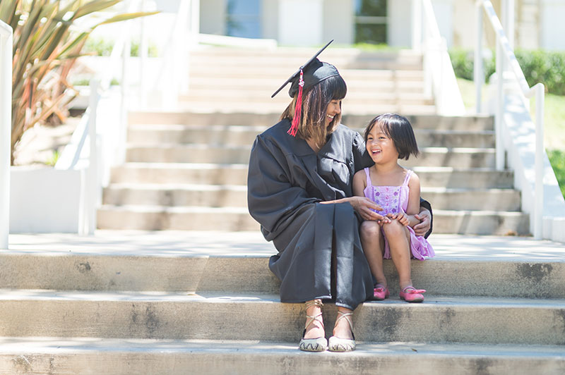 graduate-steps graduate student sitting next to a young child